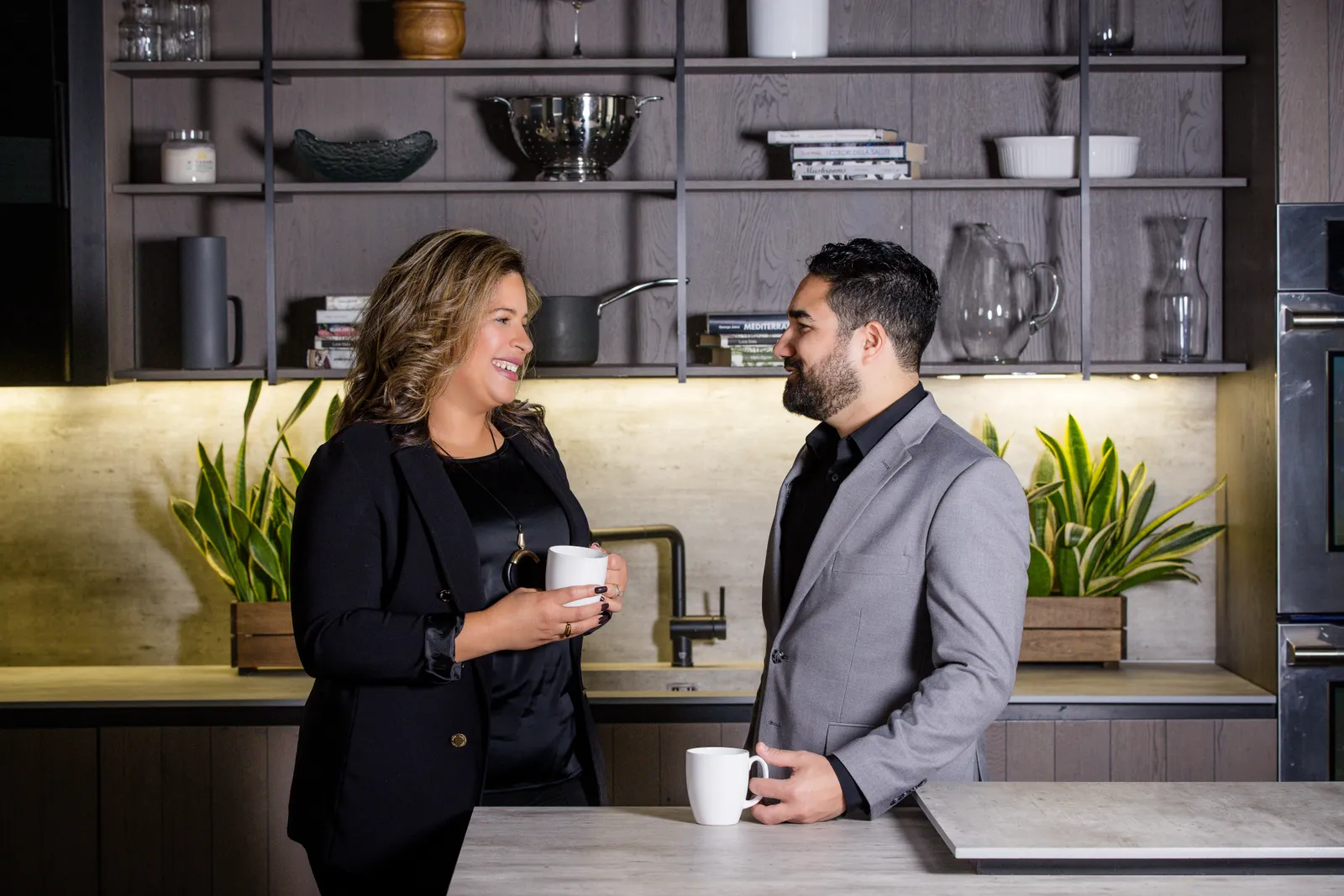 Meralis and Lester Marcano talking over coffee at a kitchen island.
